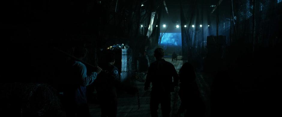 The Rangers walk through the darkened warehouse to where a man is tied to a chair.