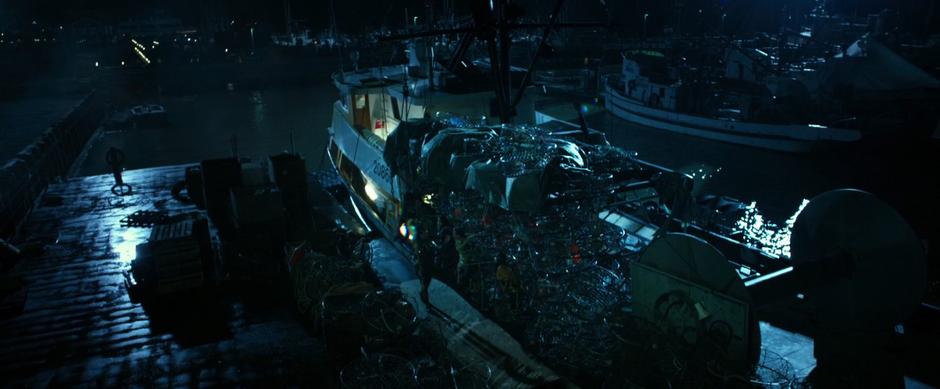 Rita walks past the team who she has tied to a fishing boat on the dock.