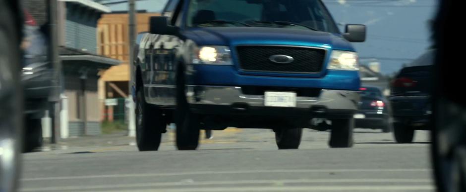 Sam continues to swerve to avoid debris and other cars while driving into town.