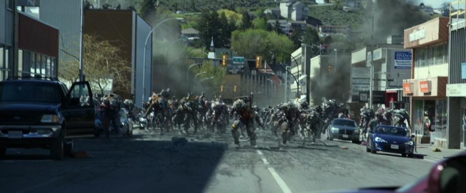 A whole swarm of Putties run down the street towards camera.