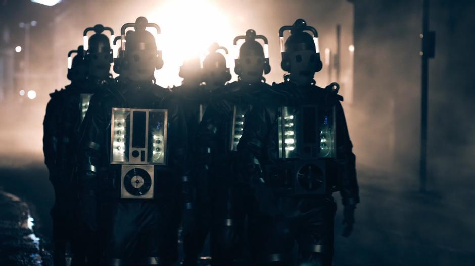 A group of Cybermen march down the street towards the hospital.