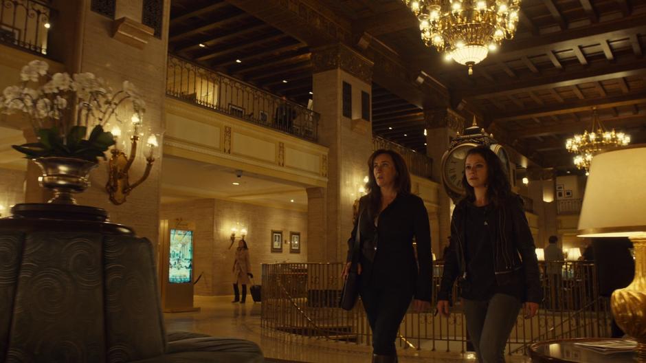 Siobhan and Sarah walk through the hotel lobby.