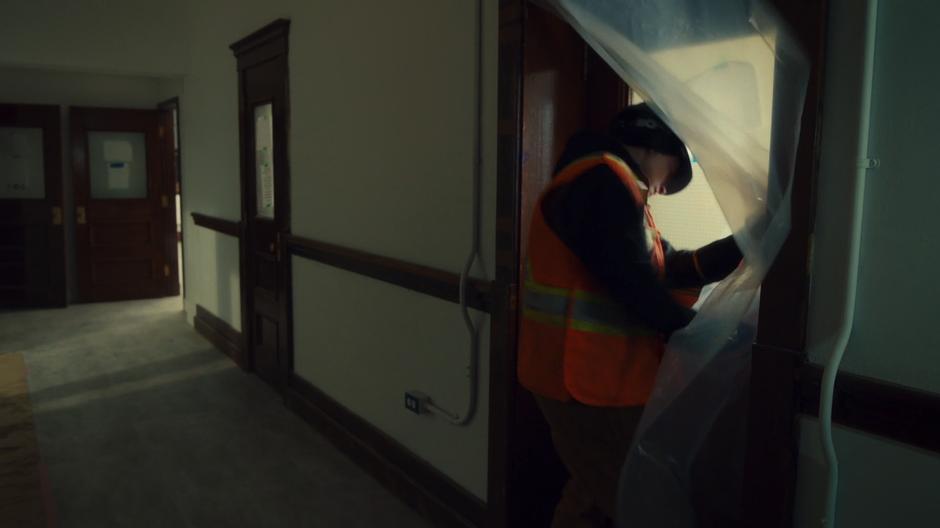 Earl in his high-vis vest and hard hat tries to get into one of the former classrooms.