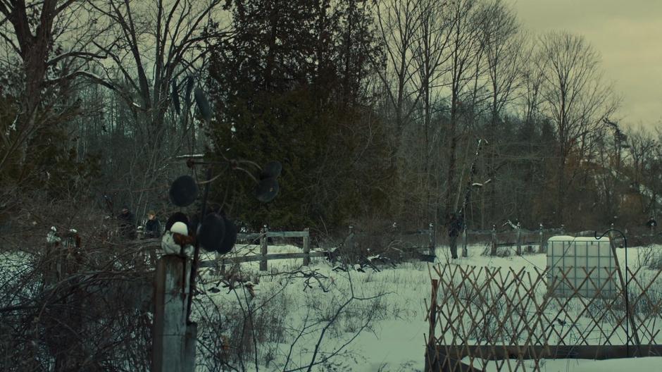 Mud and the guard walk down a snowy path near the village and discuss the "bear" in the woods.