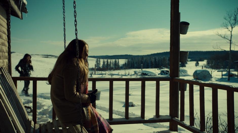 Wynonna walks around the corner to where Waverly is sitting on the porch swing with a pair of mugs.