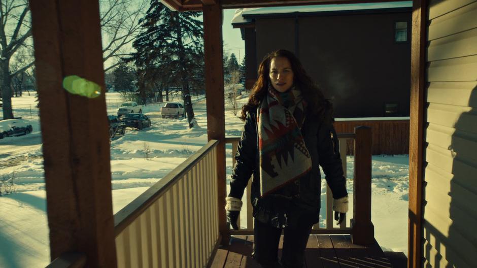 Wynonna comes around the corner on the porch and sees Skip lying in front of his door.