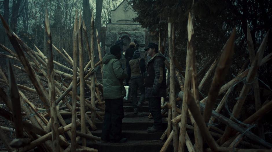 Rachel walks up the stairs to the mansion which have been fortified by wooden stakes.