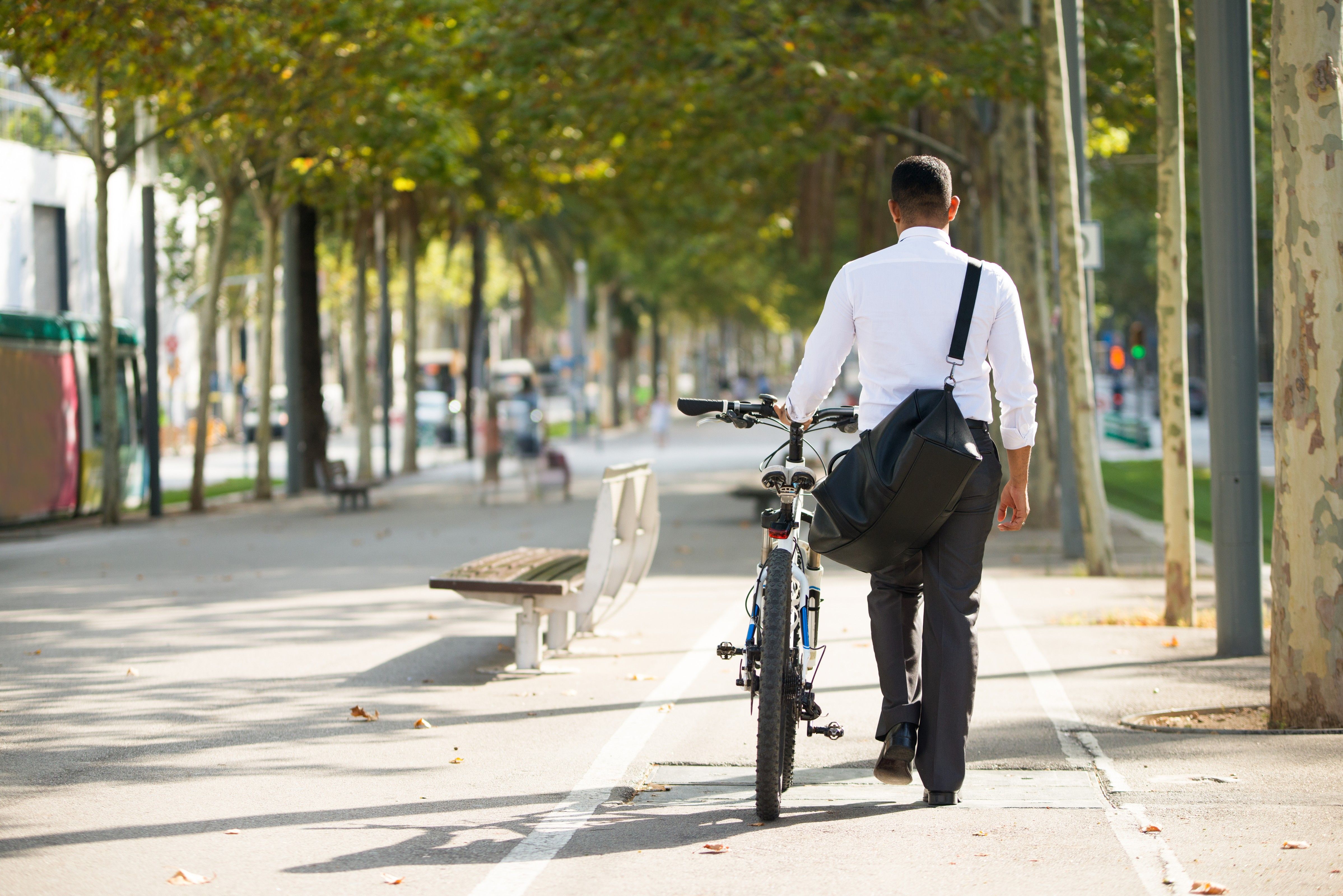 Homem andando com bike e indo para o trabalho.