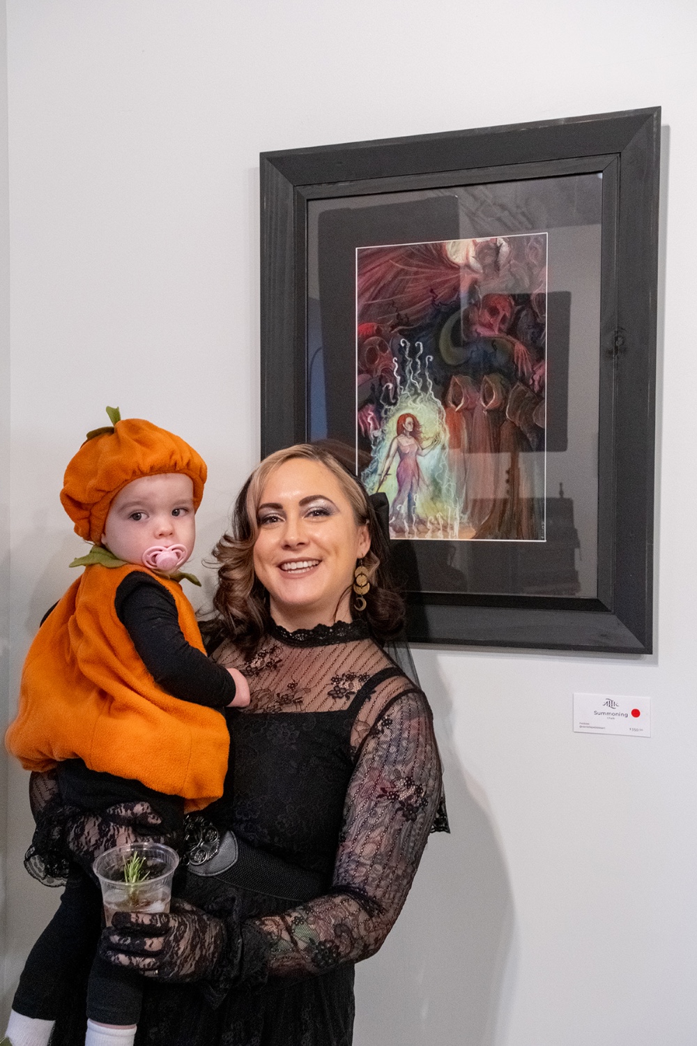 Woman holding baby dressed as a pumpkin