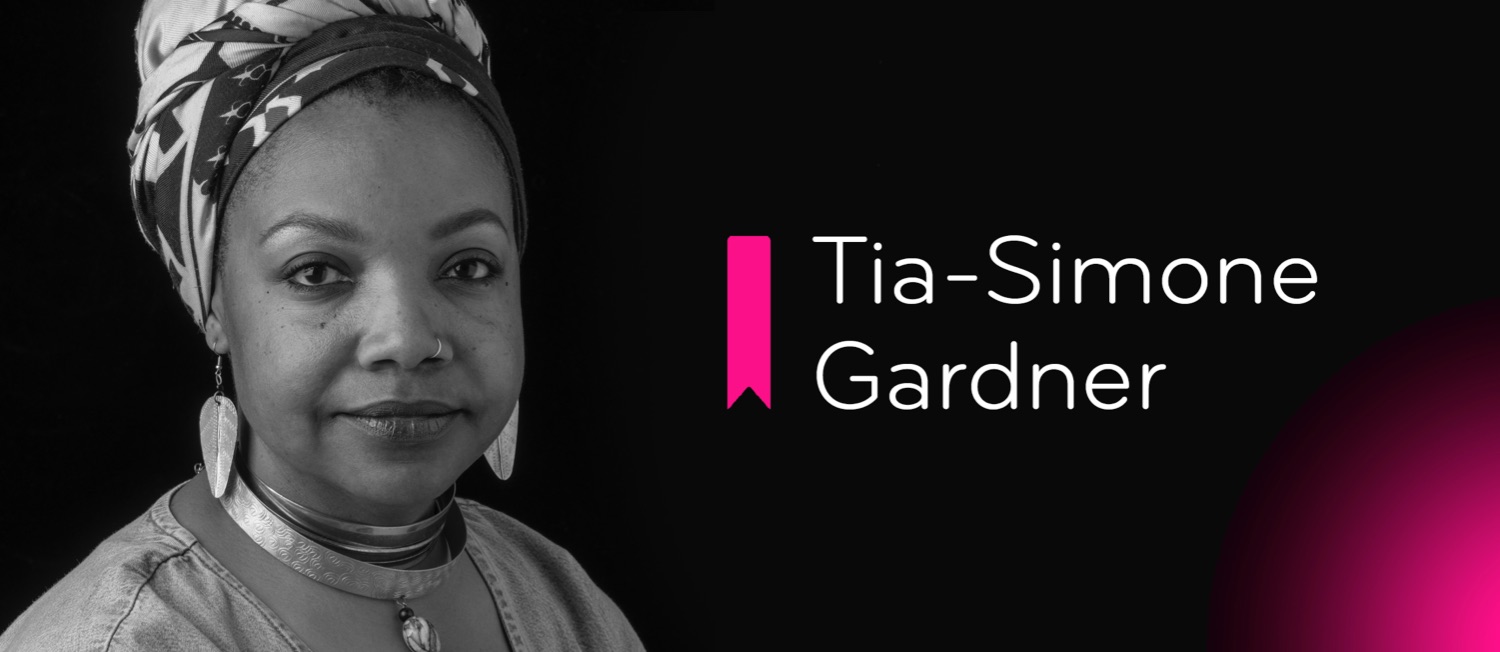 Black woman wearing elegant jewelry and a headwrap on black background with pink light in corner