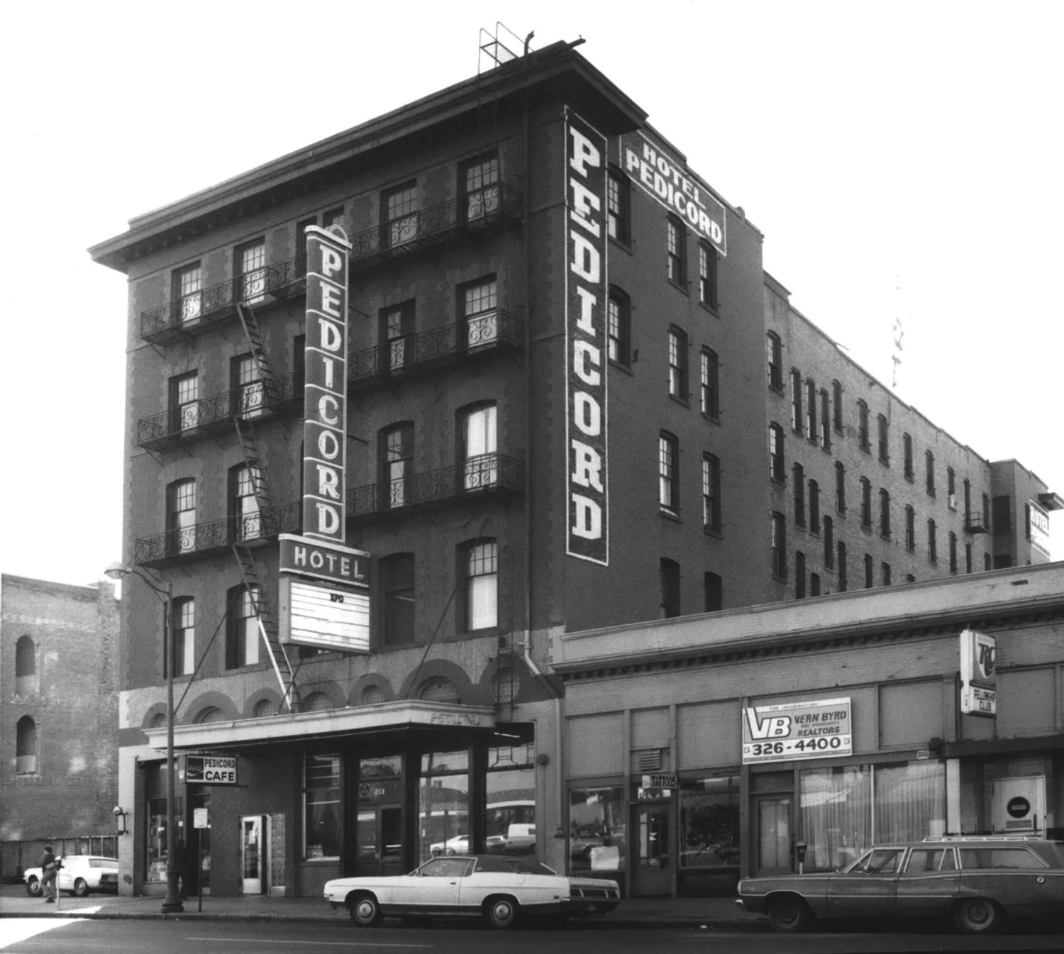 1970s-era black and white street scene of 5-story Pedicord Hotel