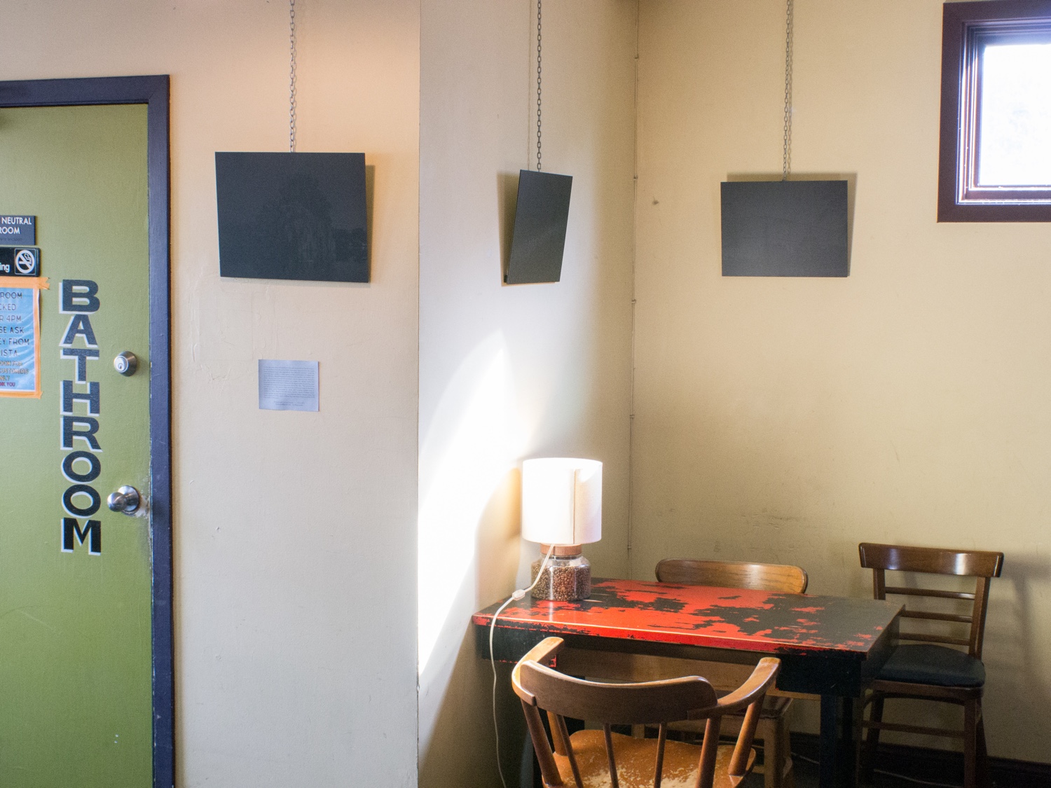 Black artworks hanging in a coffee shop