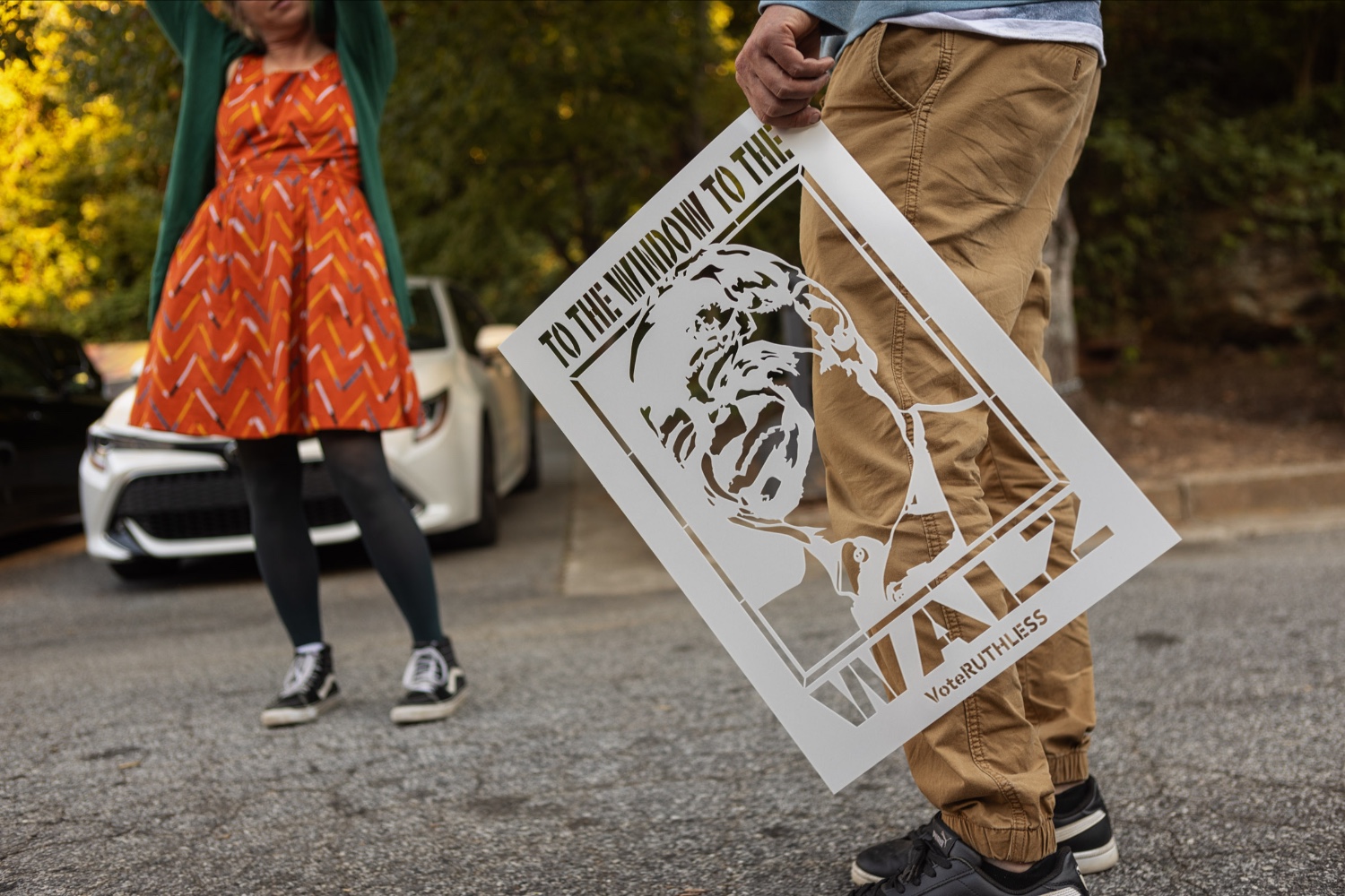 Man holding a stencil of Tim Walz