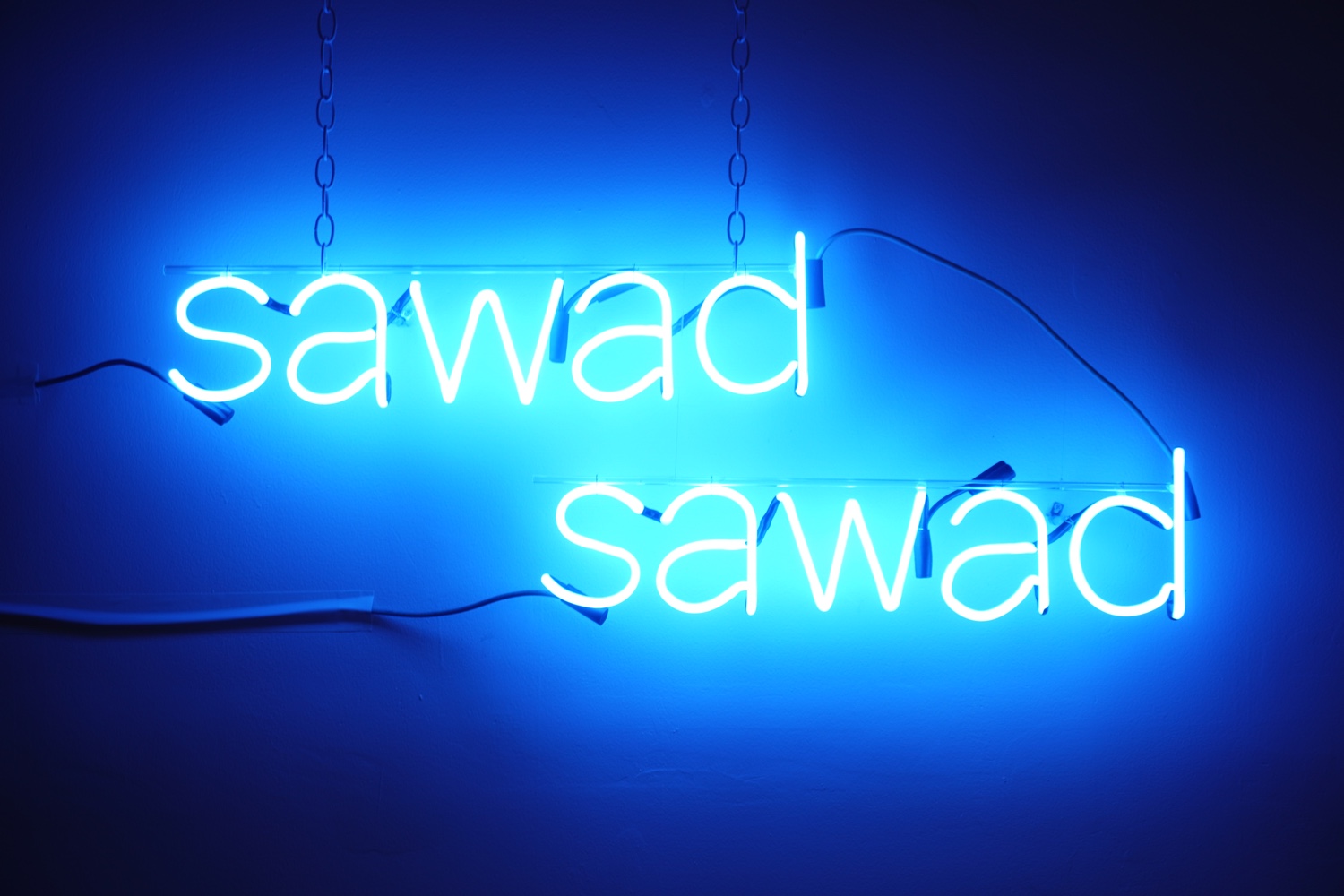 Two blue neon words: "sawad, sawad"