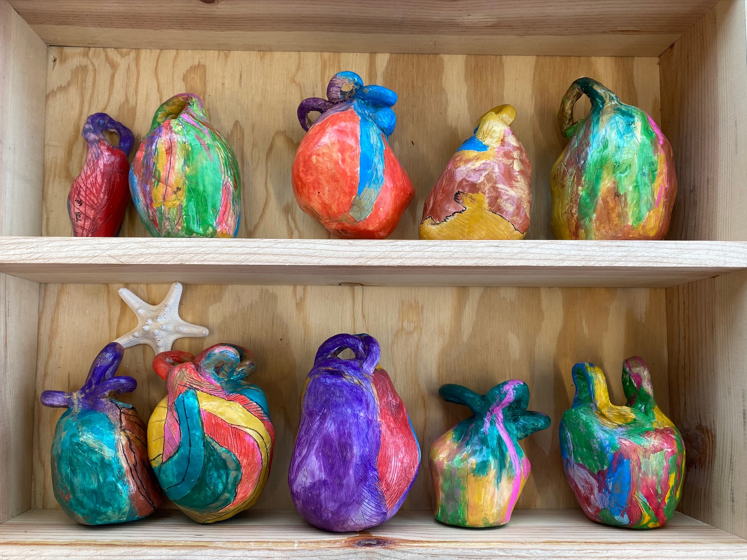 Two shelves of multi-colored ceramic sculptures