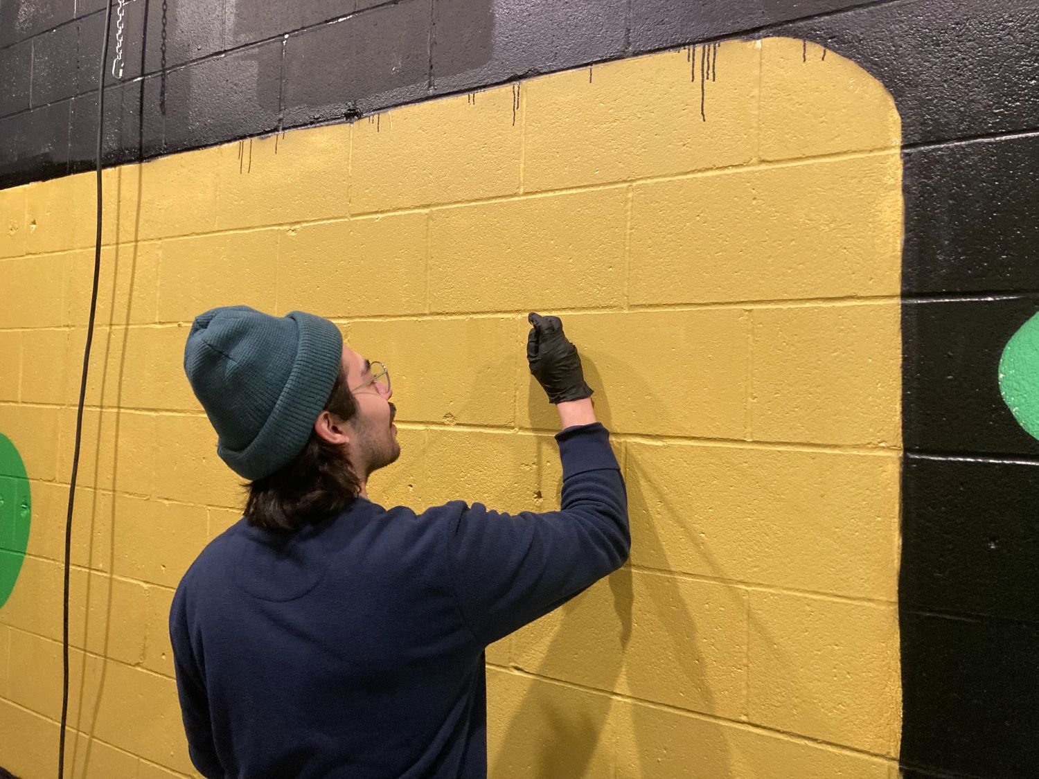 Artist Jose Dominguez works on his mural at Southside Preservation Society