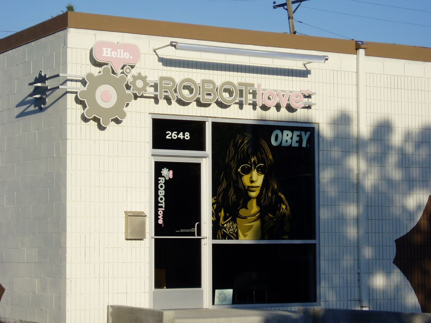 Storefront called "robot love" with stencil artwork of Joey Ramone in the window