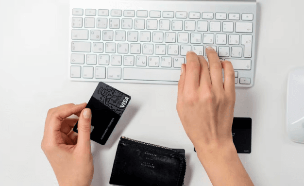 A woman uses her bank card to make a purchase on an e-commerce site