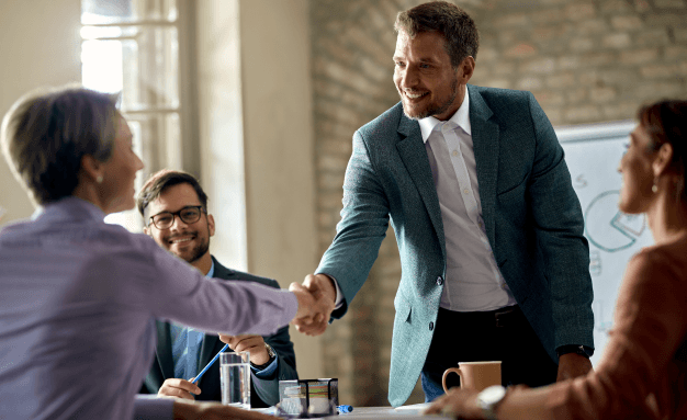 Two smiling men shaking hands during a meeting