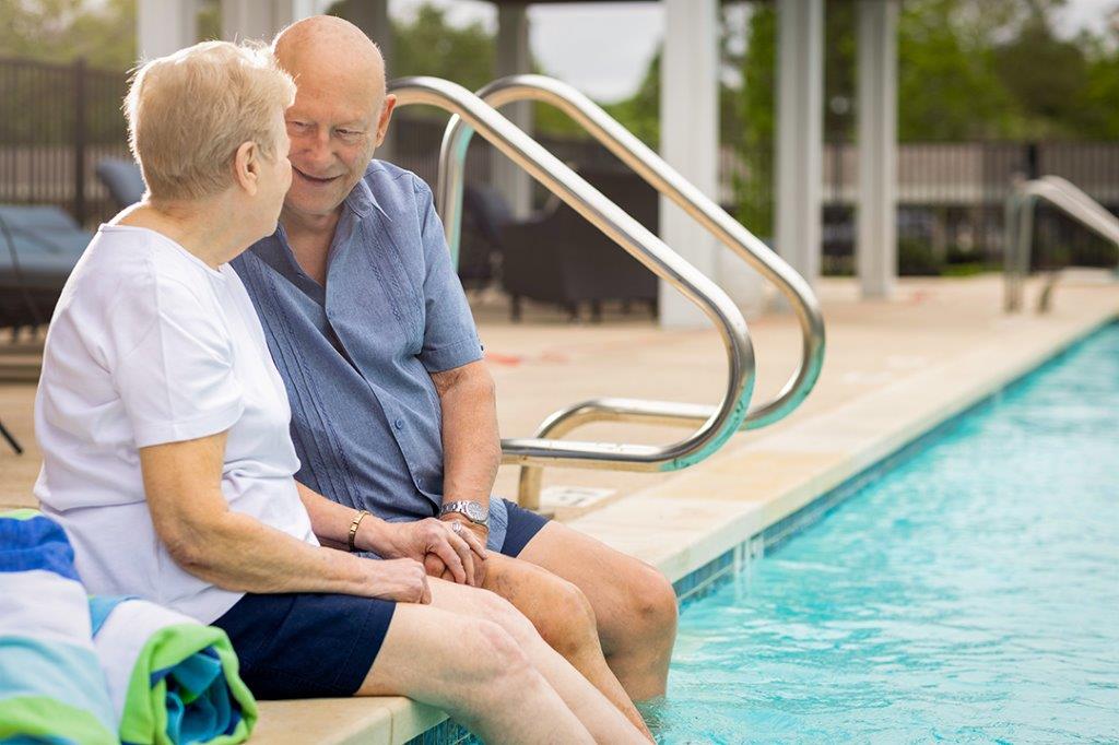 residents chatting with their feet dangling in the pool