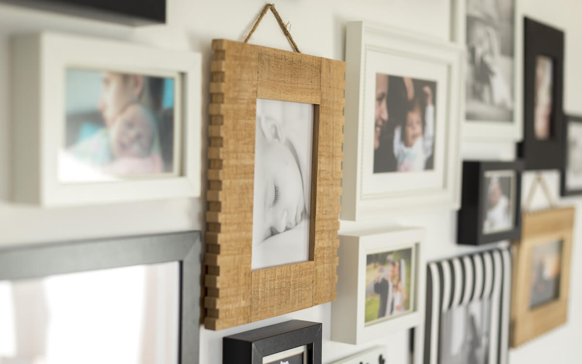 Artistic wooden picture frame hanging on a wall amongst other pictures