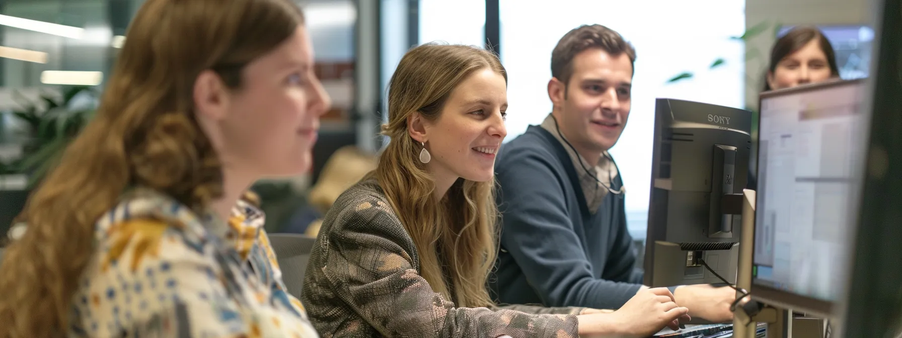 Team members engaged in RFP content management, working diligently on computers in a modern office environment.