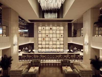 Elegant luxury lounge bar with plush seating, illuminated wall display of fine spirits, and modern chandelier lighting. Elegant luxury lounge bar with plush seating, illuminated wall display of fine spirits, and modern chandelier lighting.