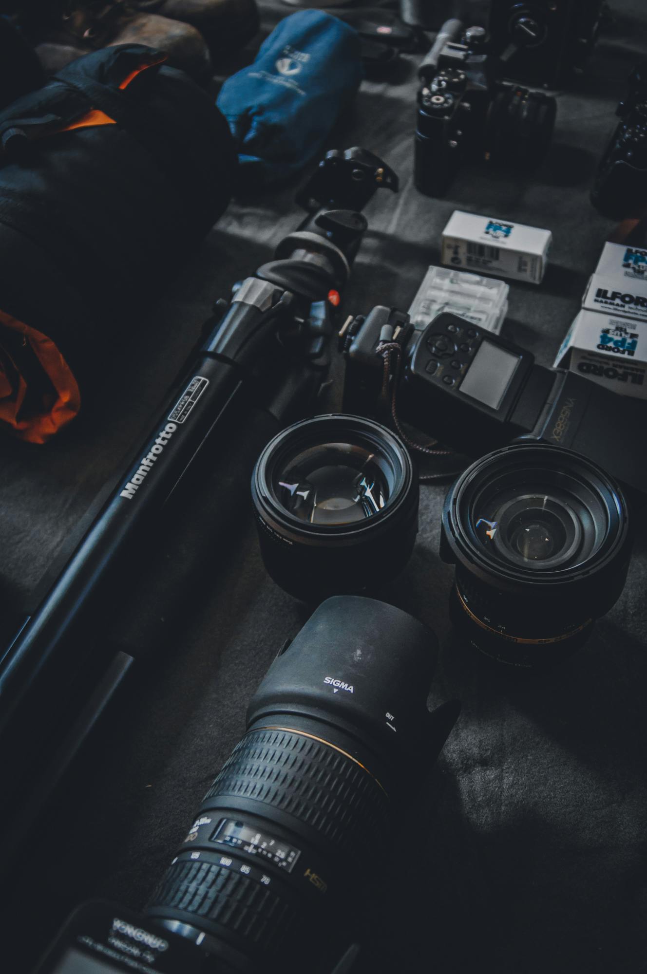 the image shows a photographer's setup with cameras, lenses, a tripod, and accessories, suggesting a professional and versatile toolkit the image shows a photographer's setup with cameras, lenses, a tripod, and accessories, suggesting a professional and versatile toolkit