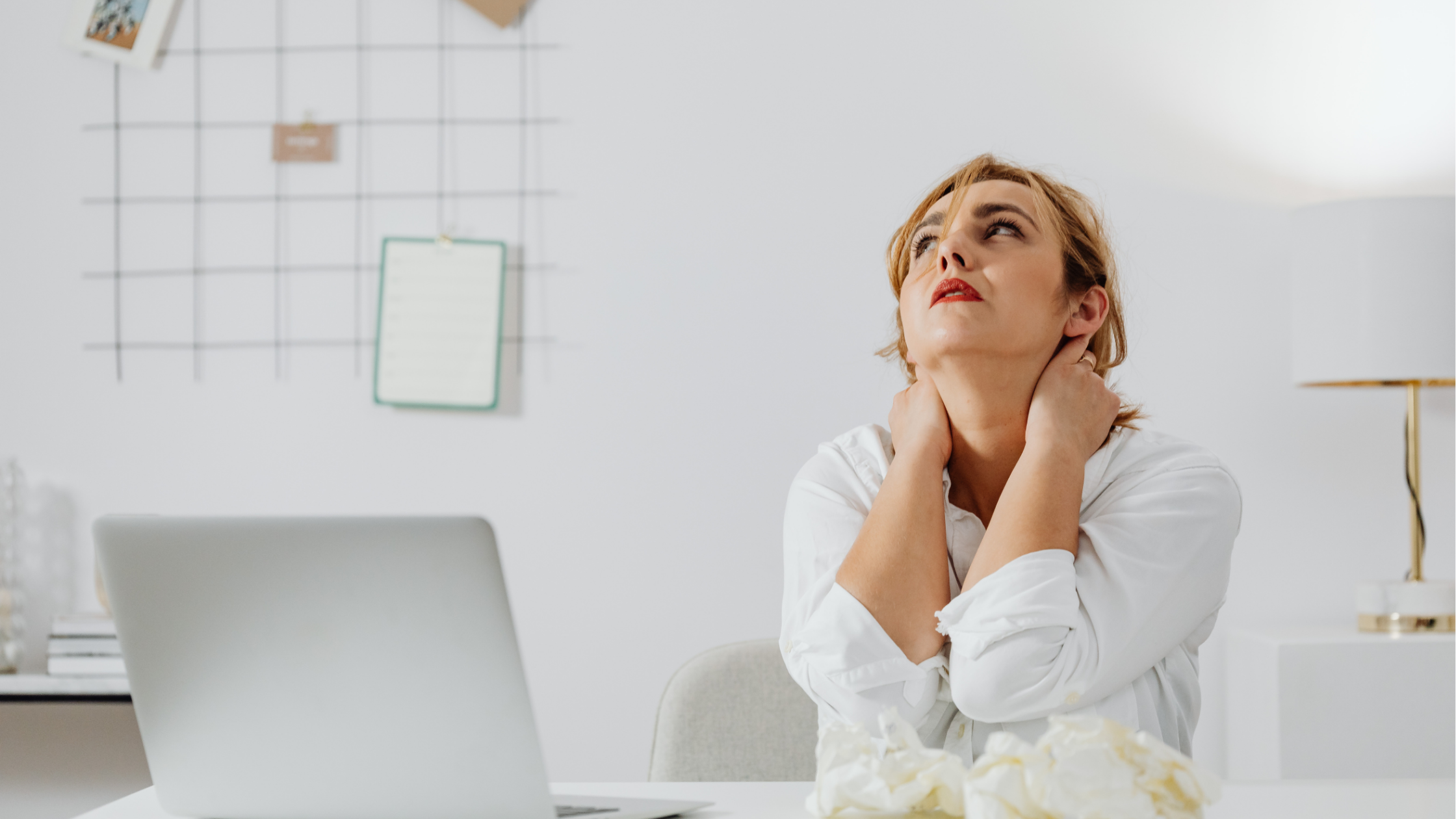 Woman with blonde hair, sitting at computer, looking stressed Woman with blonde hair, sitting at computer, looking stressed