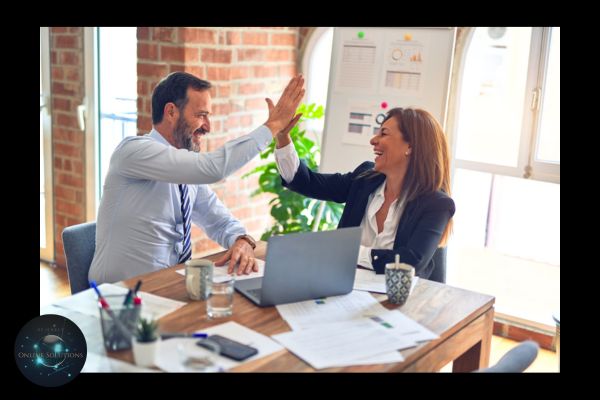 Two business professionals high-fiving at a desk, celebrating success. This image reflects the blog's theme of how a Web Chat Widget can boost productivity, streamline customer interactions, and contribute to business growth by saving valuable time.