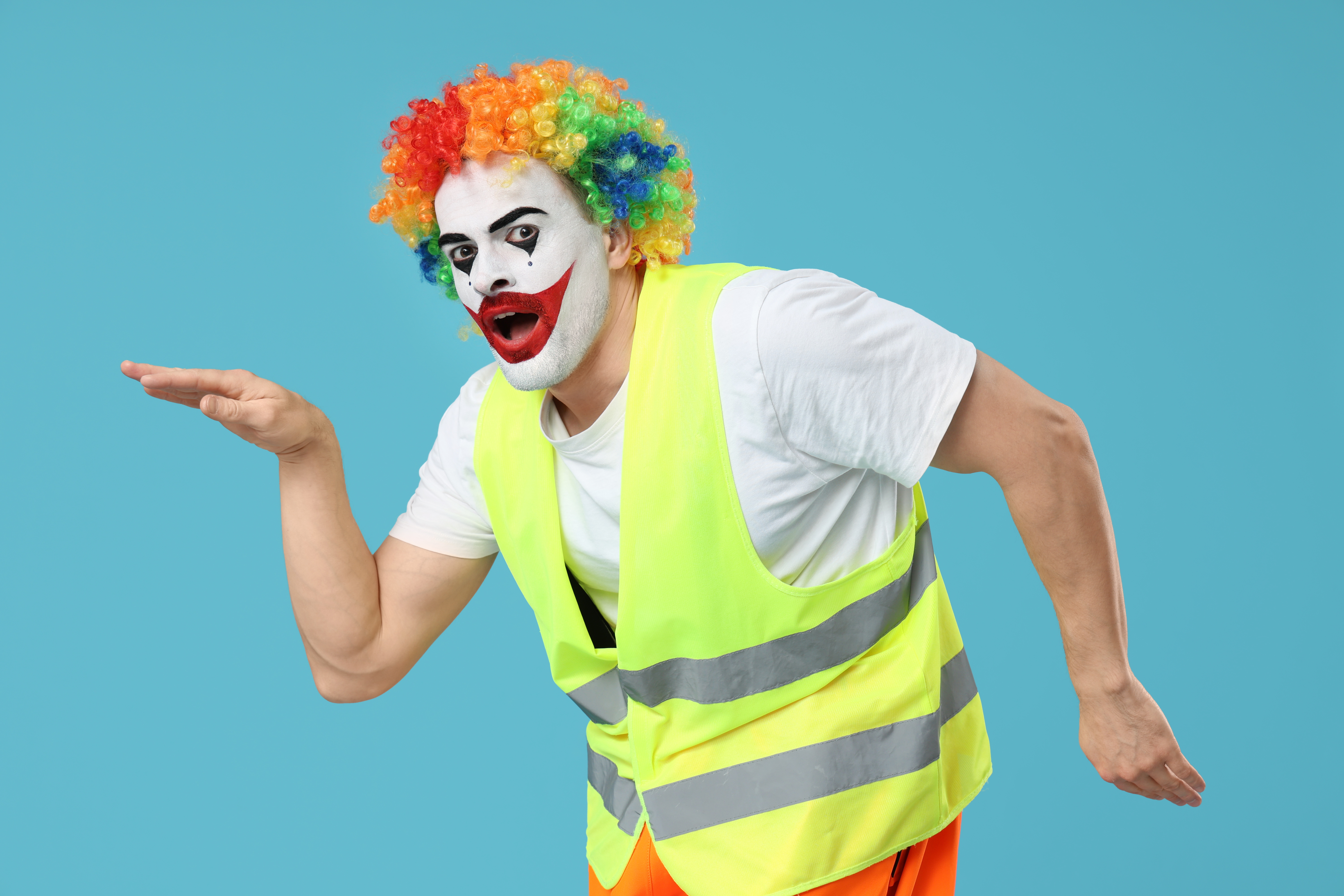Man in clown makeup and a blaze work vest dancing