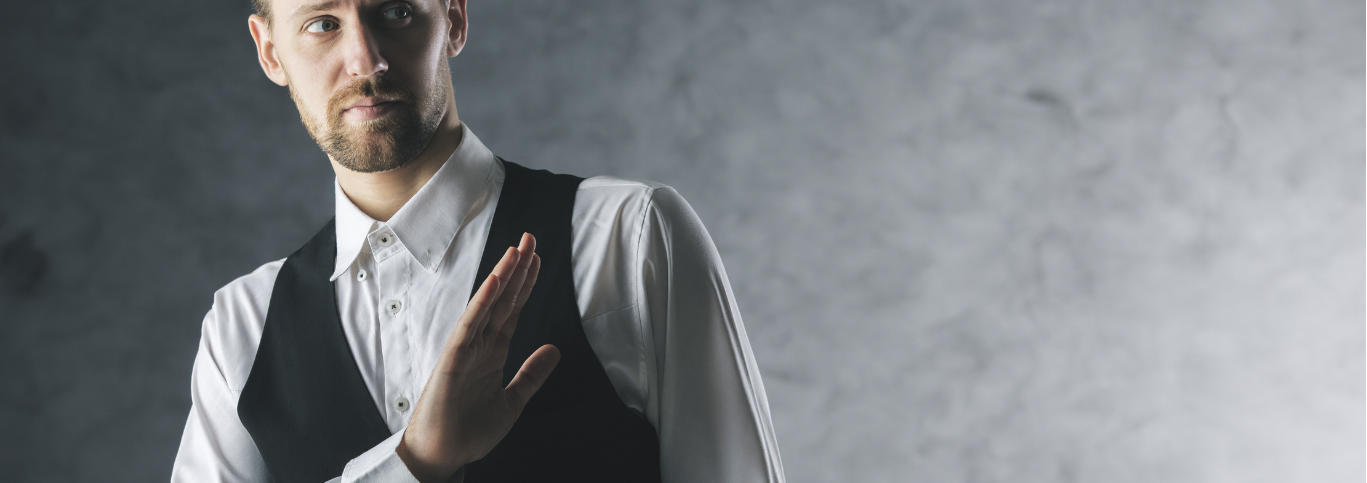 a man in a white shirt and black vest gesturing no or pass