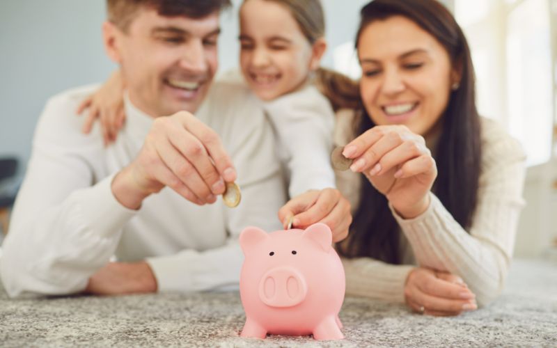 Family adding money to a piggy bank