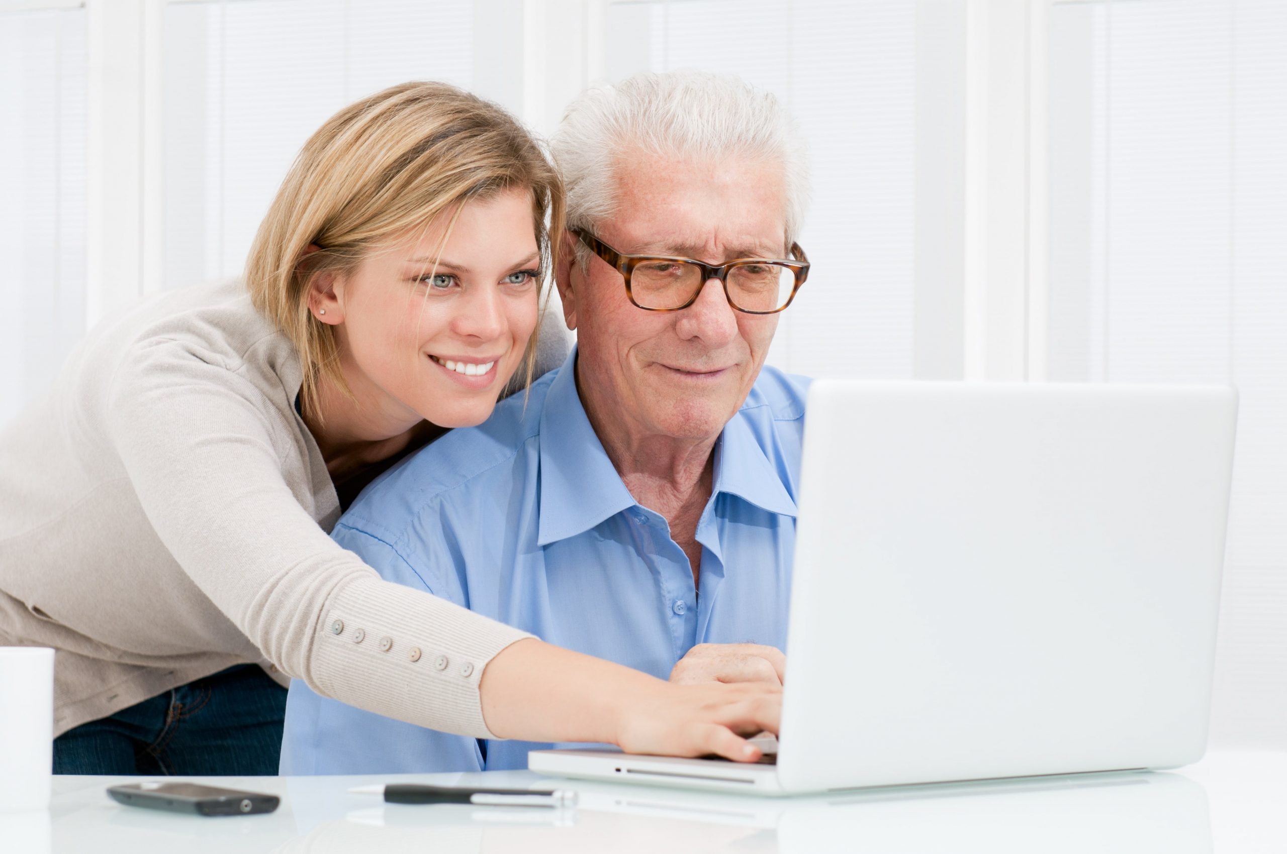 elderly man checking his computer with a woman