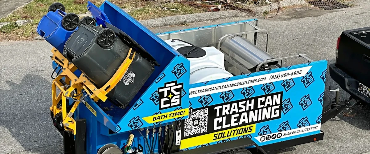 Trash can cleaning truck lifting and washing bins on the street