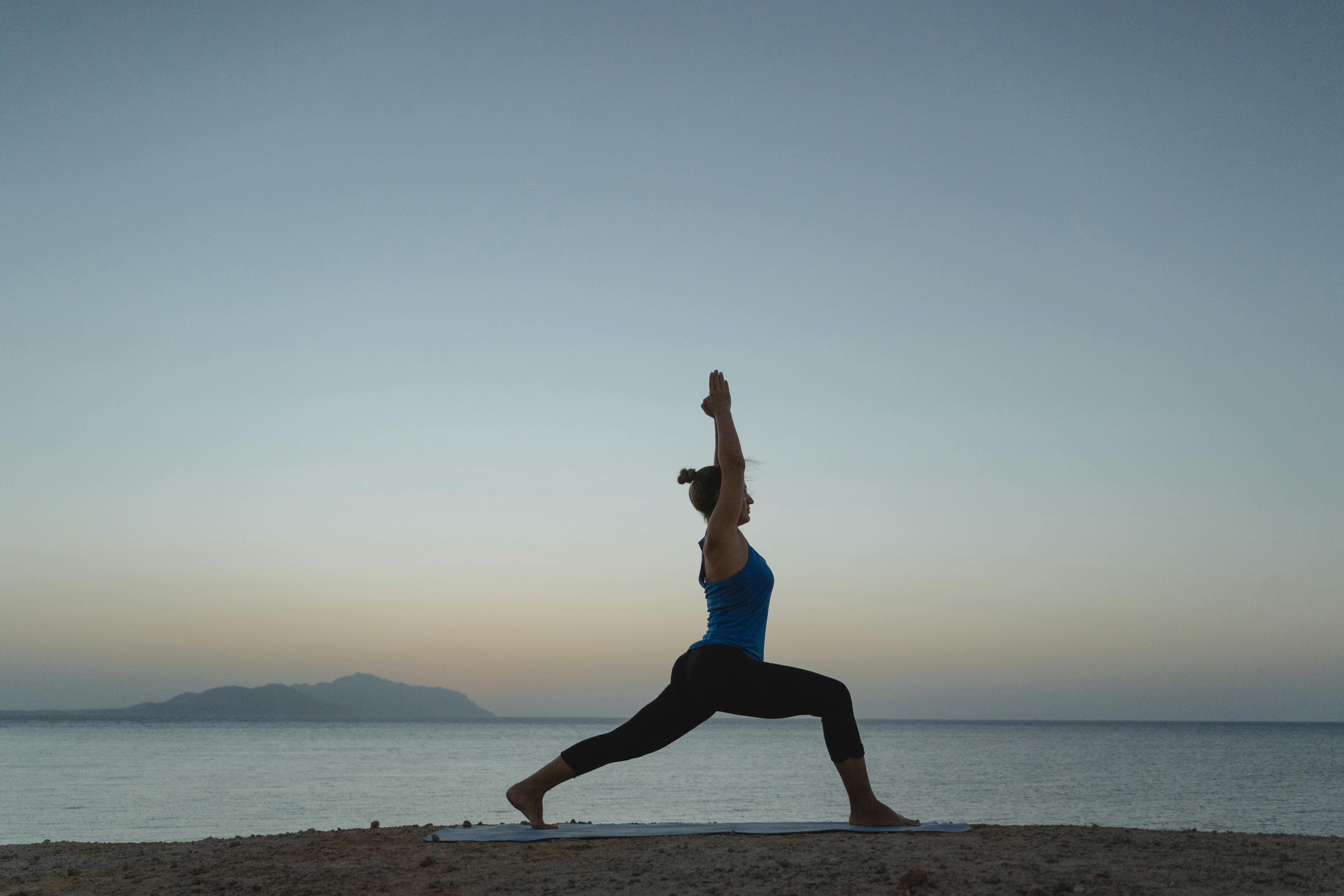 woman doing yoga on the beach