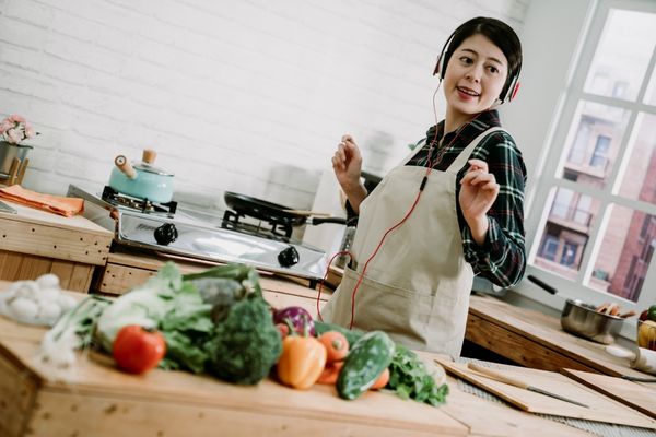 woman listening to music while cooking, relaxing kitchen environment