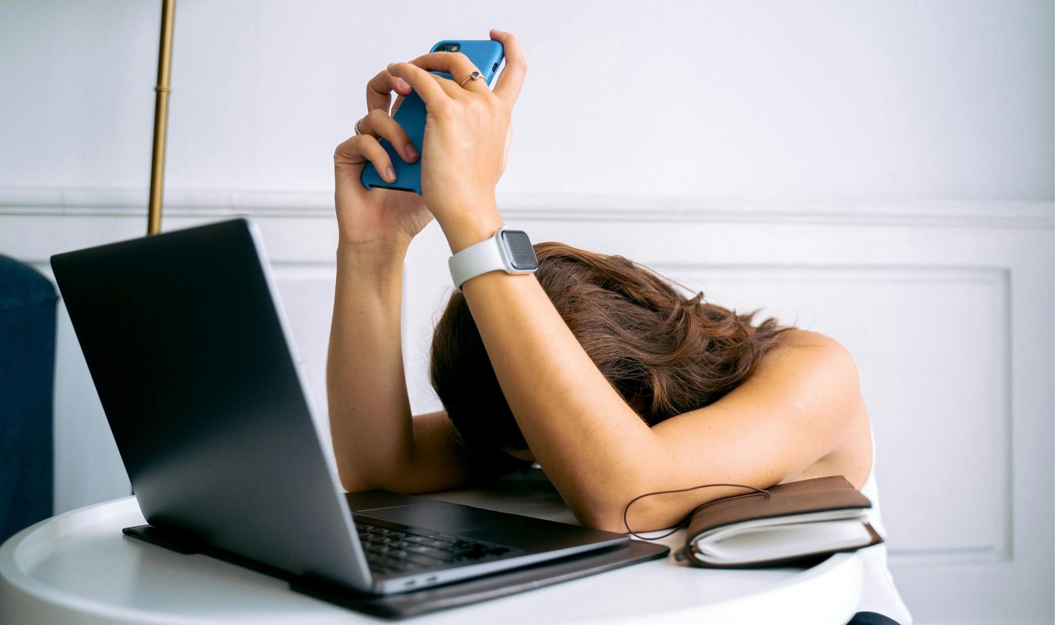 A business woman frustrated with her phone and laptop while trying to learn how to start an online business A business woman frustrated with her phone and laptop while trying to learn how to start an online business