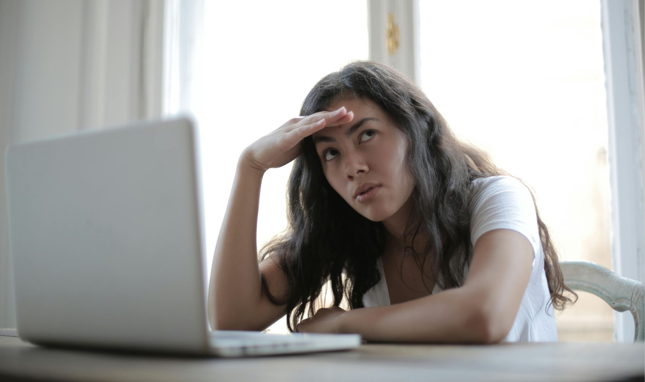 A confused business woman in front of her laptop, facing common startup challenges for entrepreneurs A confused business woman in front of her laptop, facing common startup challenges for entrepreneurs