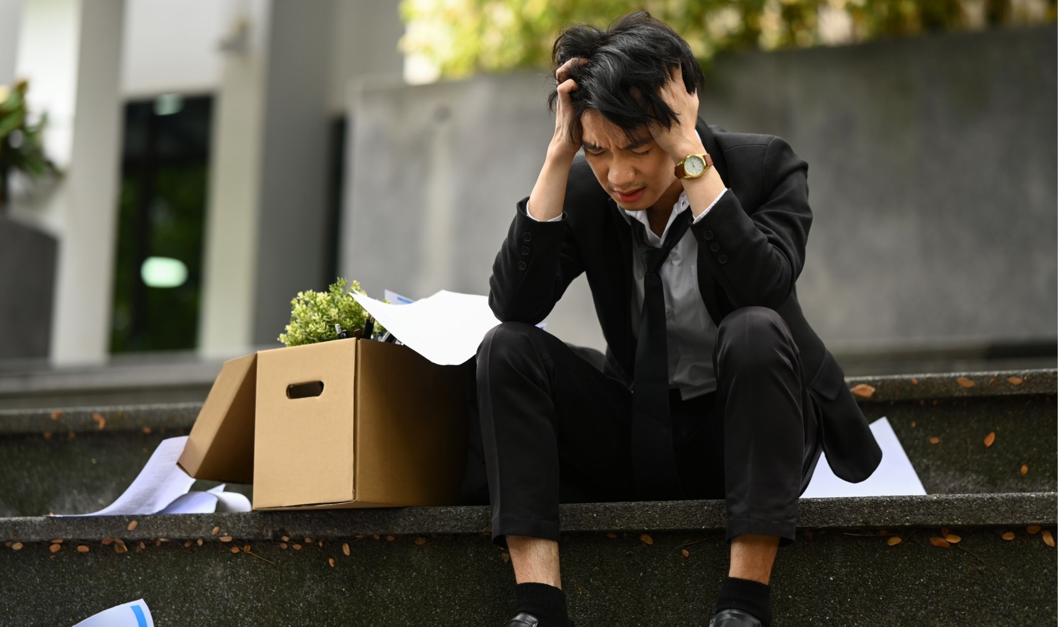 A business man sitting on steps after failing at work because of mindset blocks in online business A business man sitting on steps after failing at work because of mindset blocks in online business