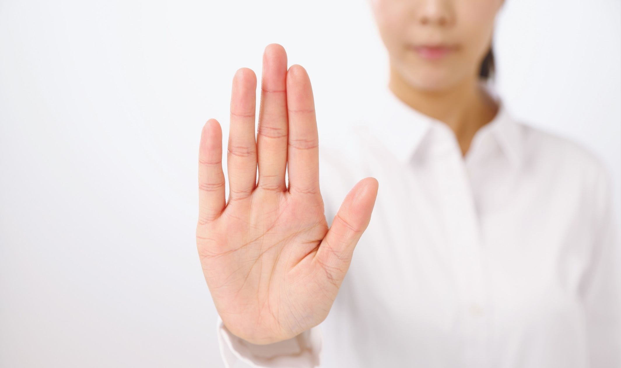 A business woman holding her hand out to stop someone