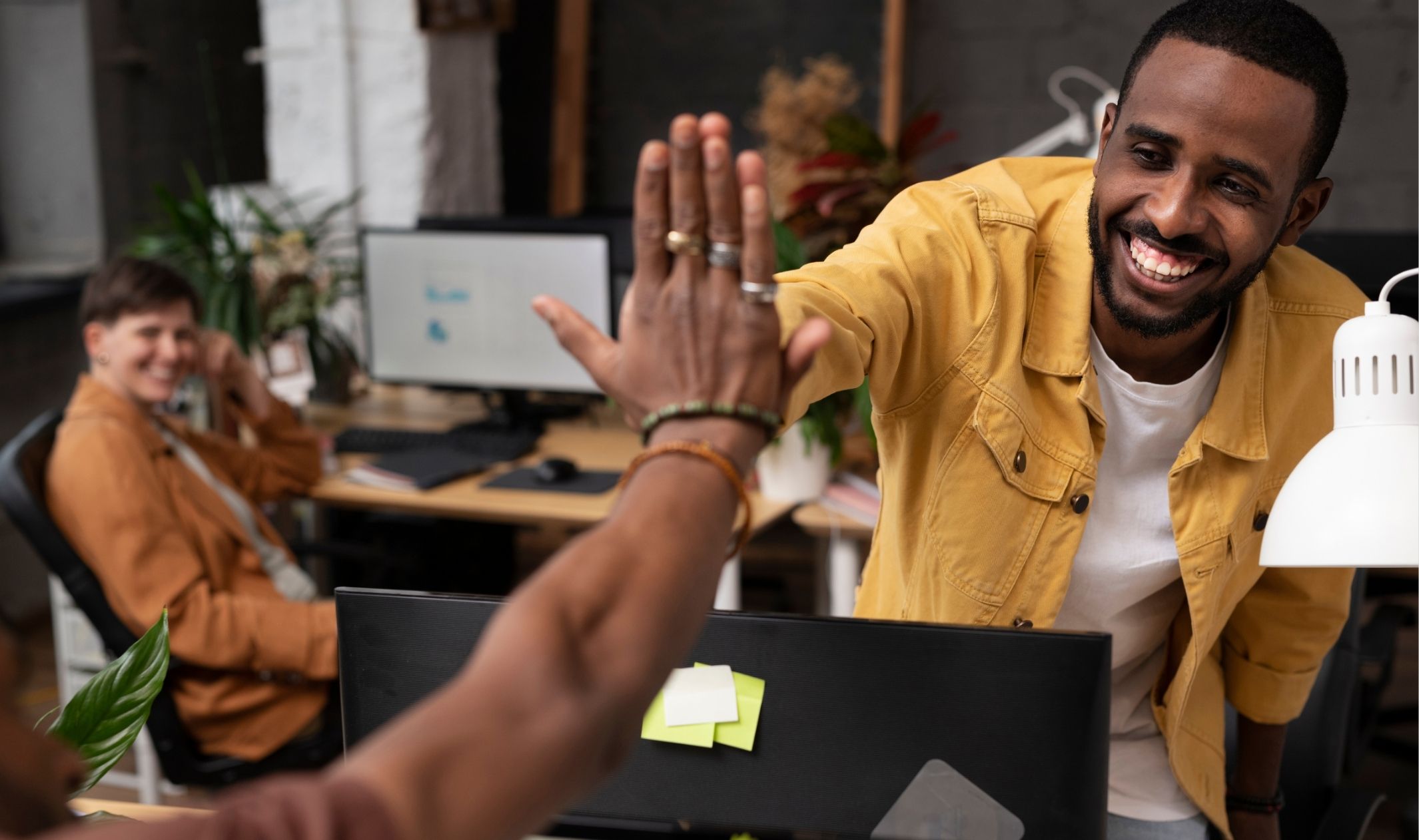 Business colleagues high fiving after successfully setting up an automated checkout system