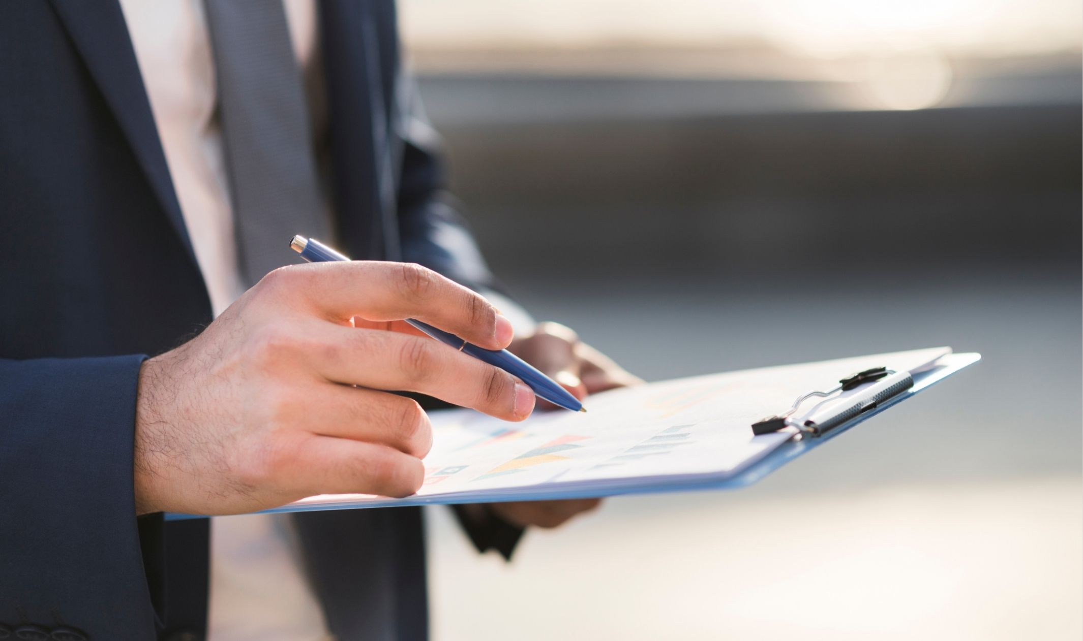 A business man going over a pre-launch checklist for online business on a clipboard A business man going over a pre-launch checklist for online business on a clipboard