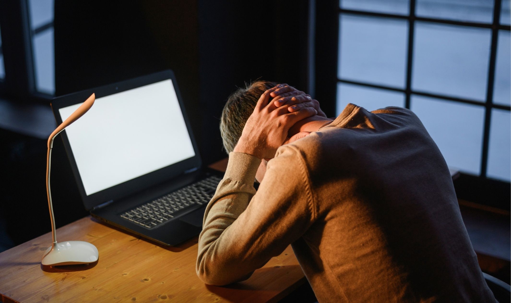 An overworked employee working at his laptop at night because he hasn't learned why overnight success is a myth An overworked employee working at his laptop at night because he hasn't learned why overnight success is a myth