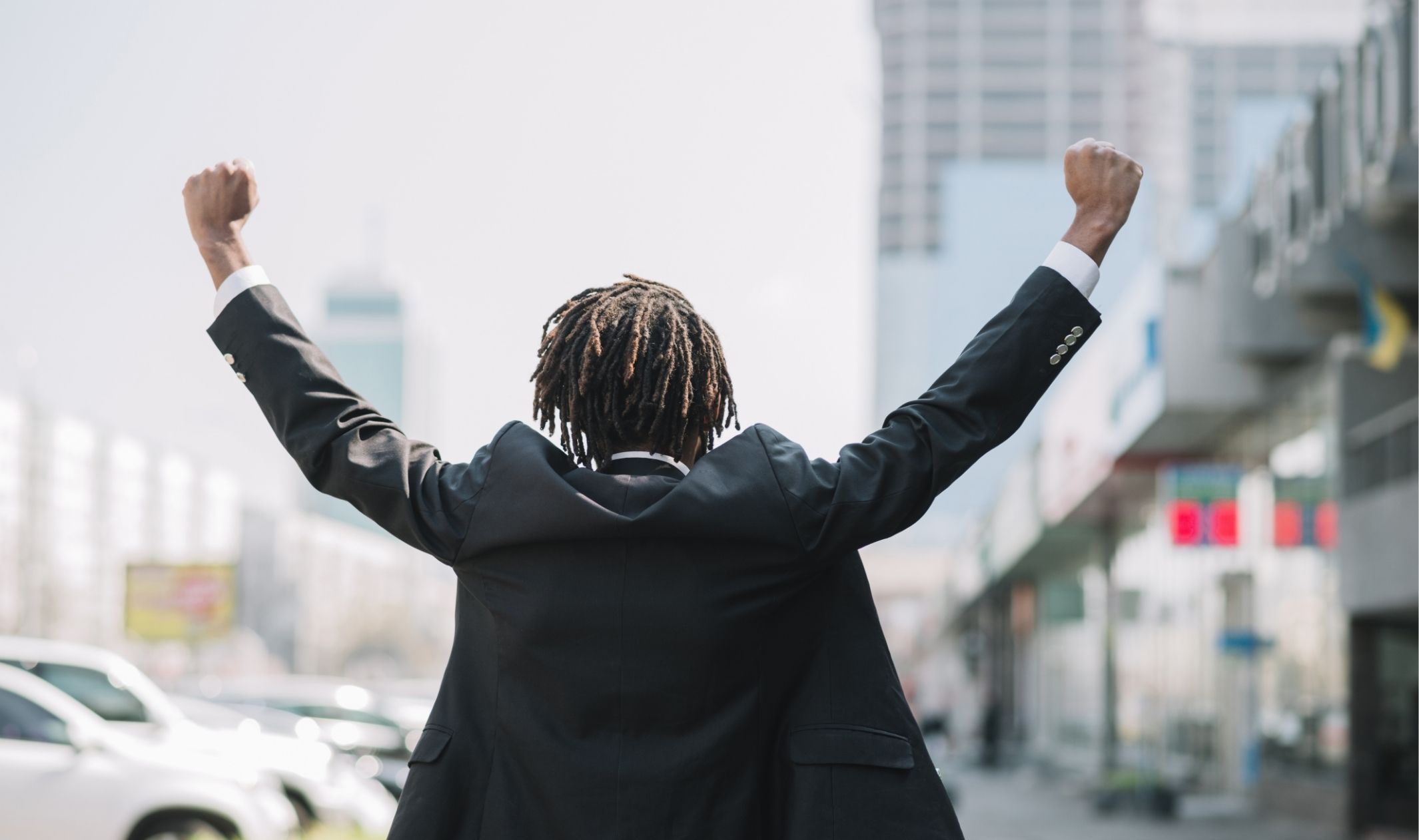 A business man holding his arms up in excitement as he implements the entrepreneurship work-life balance A business man holding his arms up in excitement as he implements the entrepreneurship work-life balance