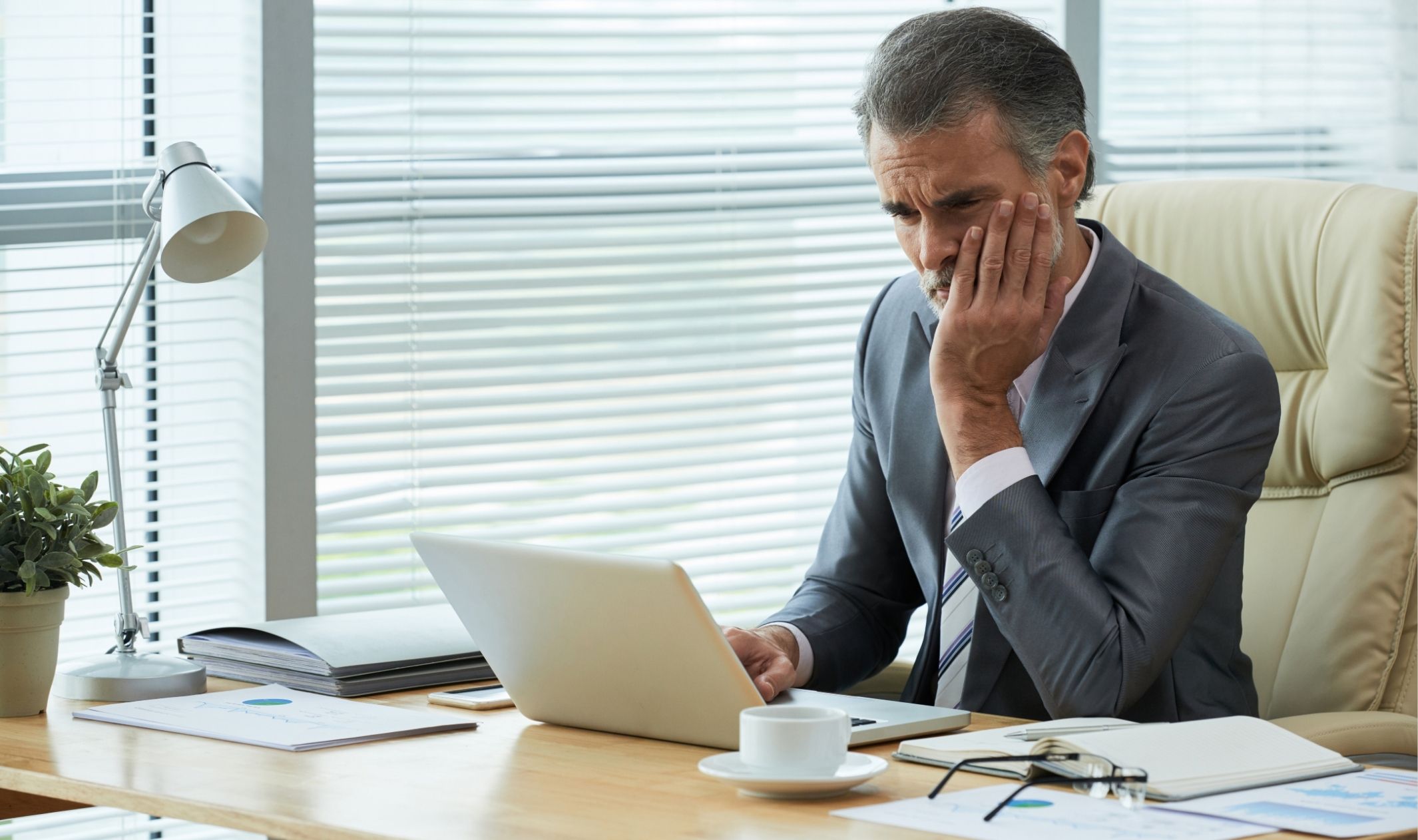 A business owner sitting at his desk, in front of his laptop, and wondering why products don’t sell without marketing A business owner sitting at his desk, in front of his laptop, and wondering why products don’t sell without marketing