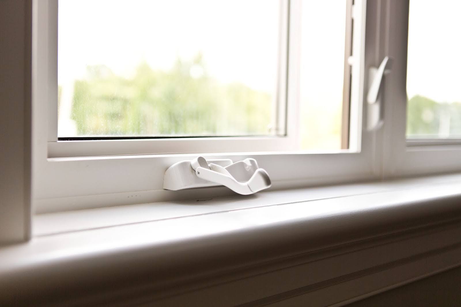 Bottom of VinylBilt window, recently installed by Fasada, with a white-handled opening mechanism.