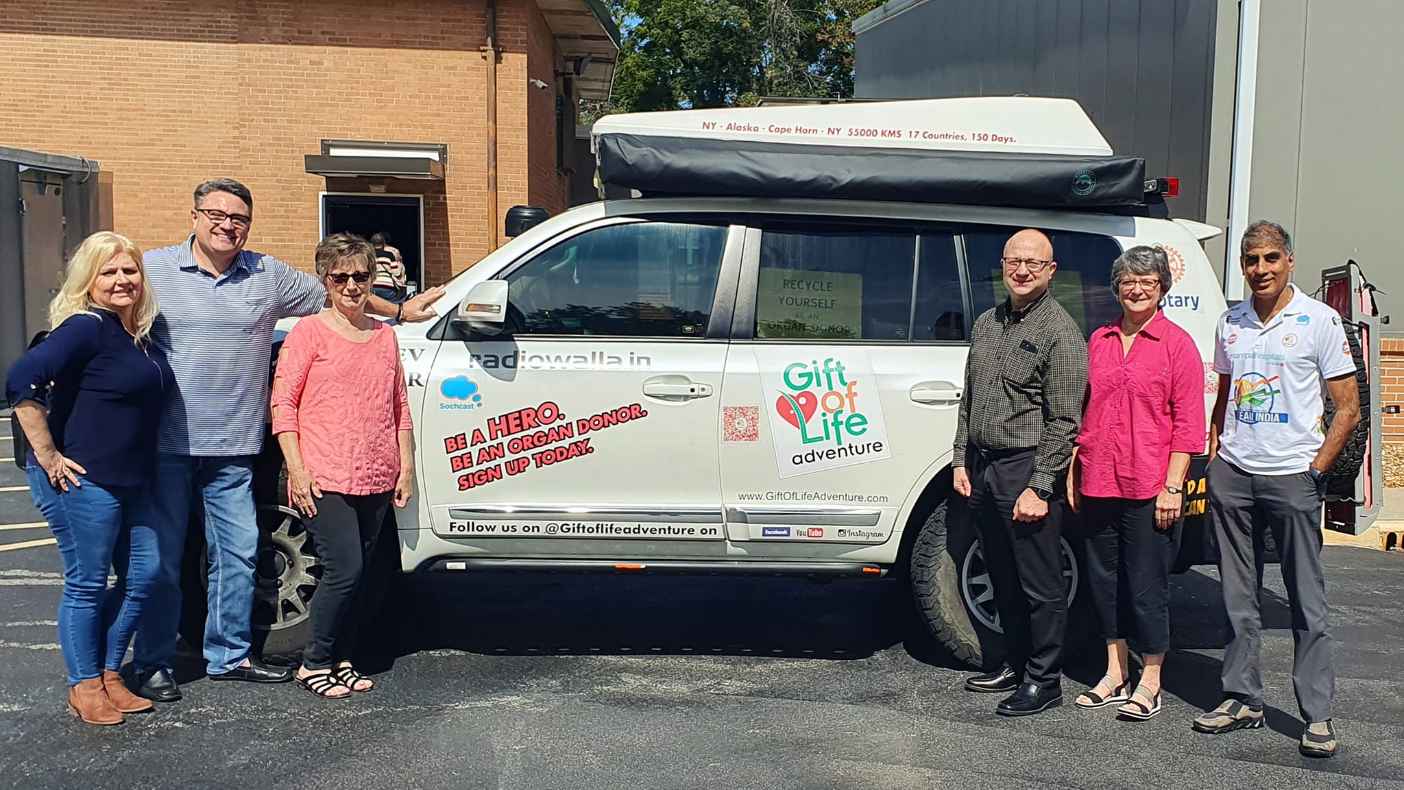 Riverbend Rotarians stand withb Anil in fron tof his decorated car he is driving 20,000 miles to spread awareness of organ donation