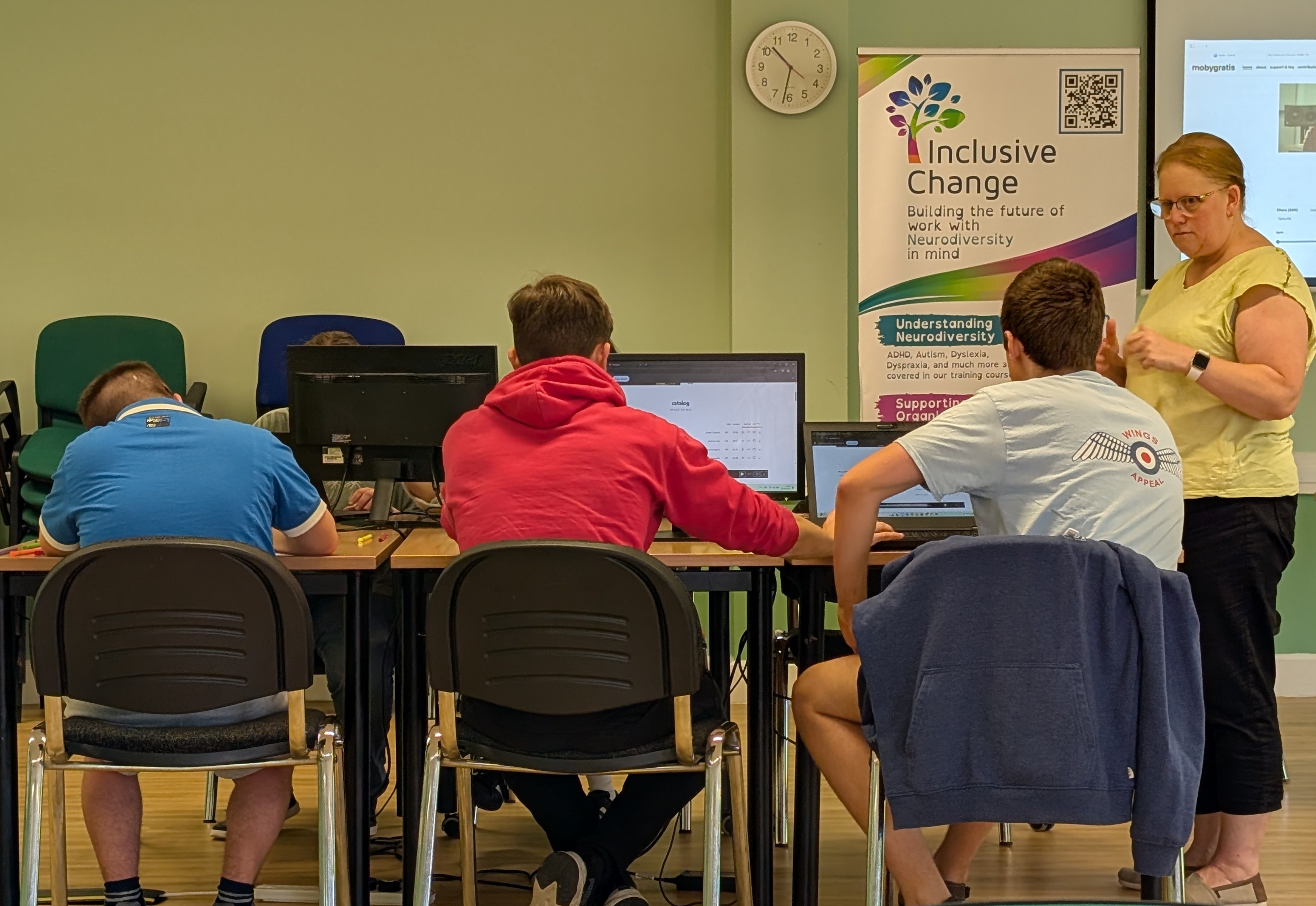 Volunteers and Lucy Smith sitting at a desk, working hard
