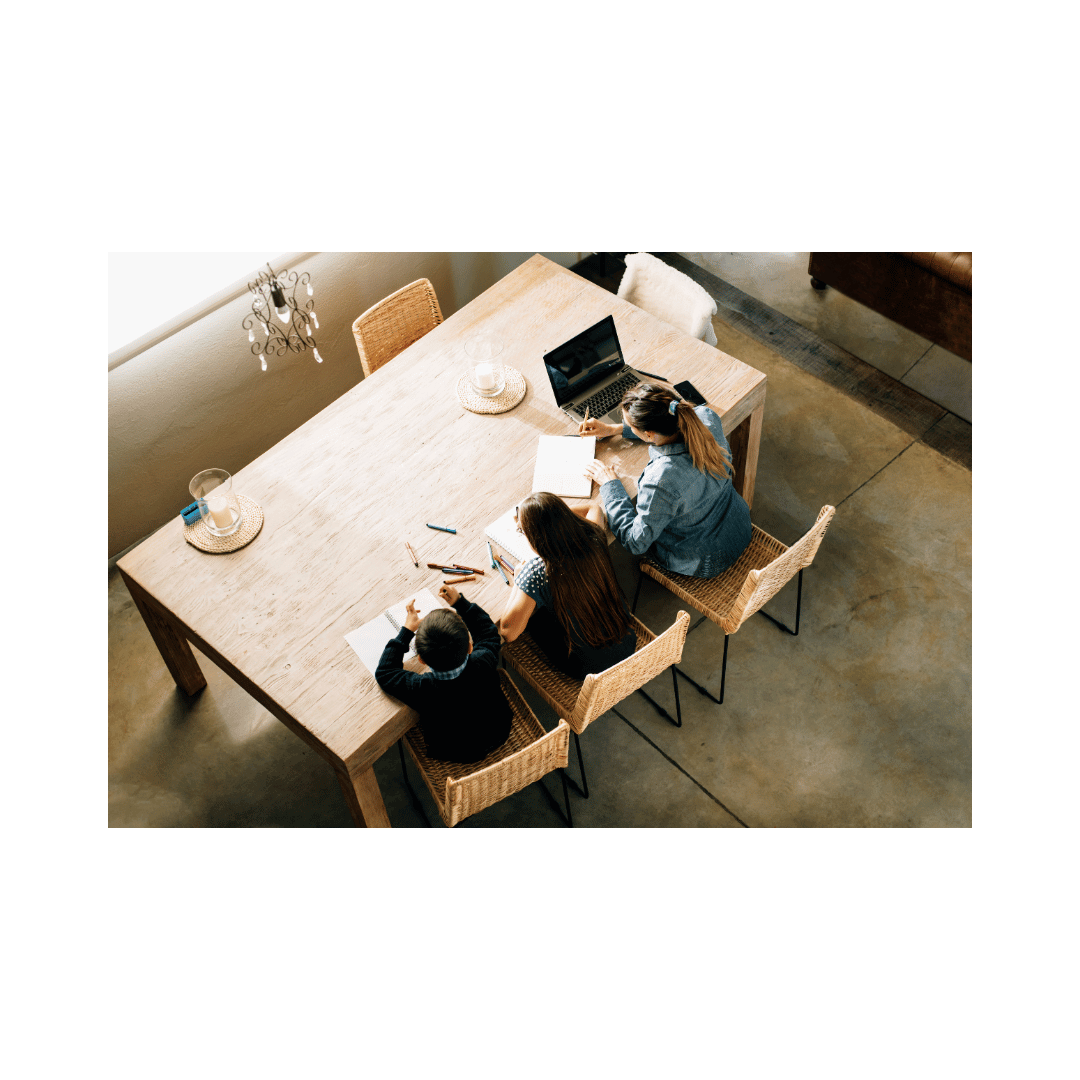 Mompreneur sitting at a desk modeling productivity to her children working next to her Mompreneur sitting at a desk modeling productivity to her children working next to her